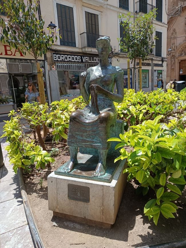 Statue sitzende Frau mit Handarbeit