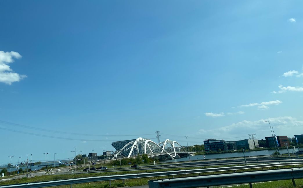 Hinter dieser Brücke steht ein Gebäude in Form eines Kreuzfahrtschiffes