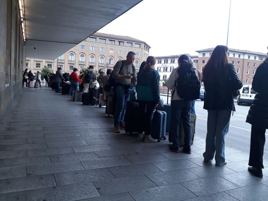 Menschen in einer endlosen Schlangewarten in Florenz auf ein Taxi