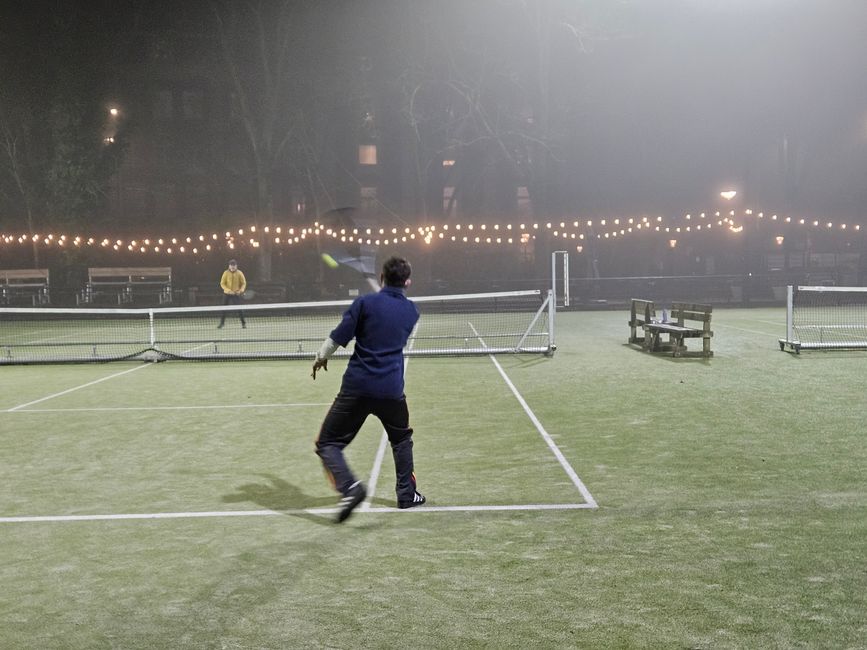 Am Wegesrand spielen bei eisigen Kälte am Abend noch Menschen Tennis