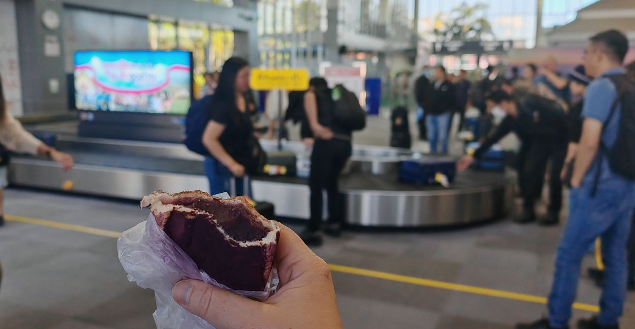 Kleiner Zwischensnack, purple sweet potato. Im Hintergrund die komplette (!) Ankunftshalle