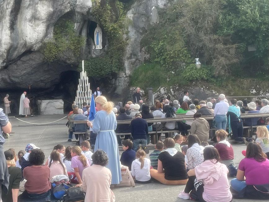Betende Menschen vor der Grotte.