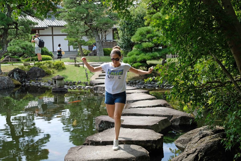 Yumi fühlt sich im japanischen Garten der Hiimeji-Burg sichtlich wohl und spielt dort ein Runde Jump-and-Run.