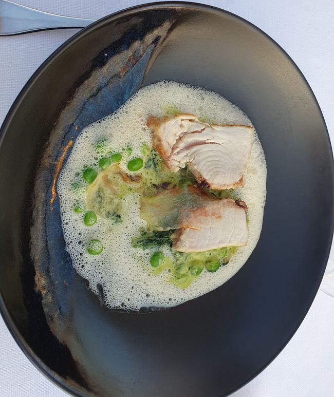 Wolfsbarsch(?) auf Erbsen und Püree davon mit Lardo und Schaum davon.