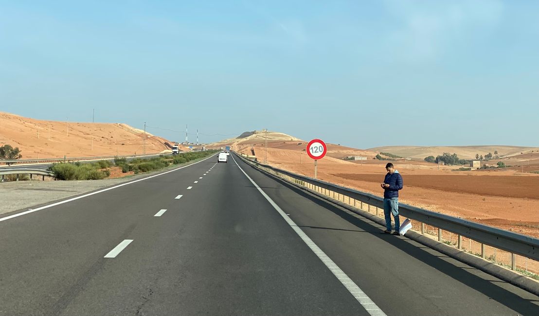Normale Szene auf der Autobahn - dieser junge Mann wartet seelenruhig am Fahrbahnrand