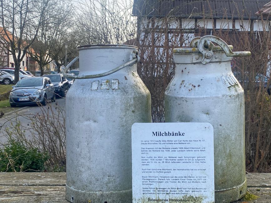 Zwei alte Milchkannen auf der Milchbank