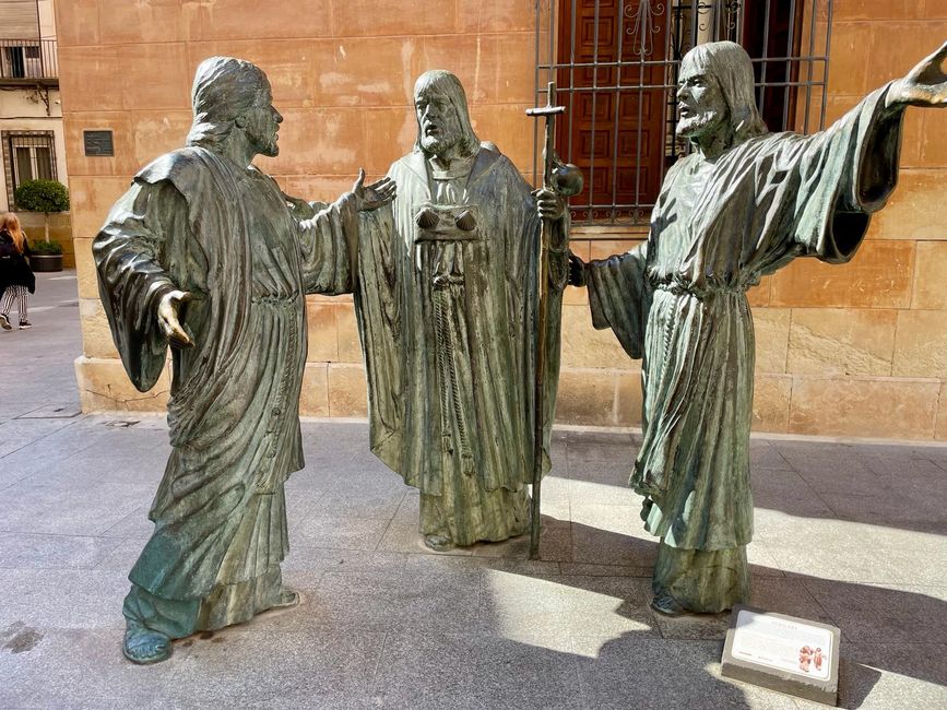 Three bronze apostles stand in front of the basilica.