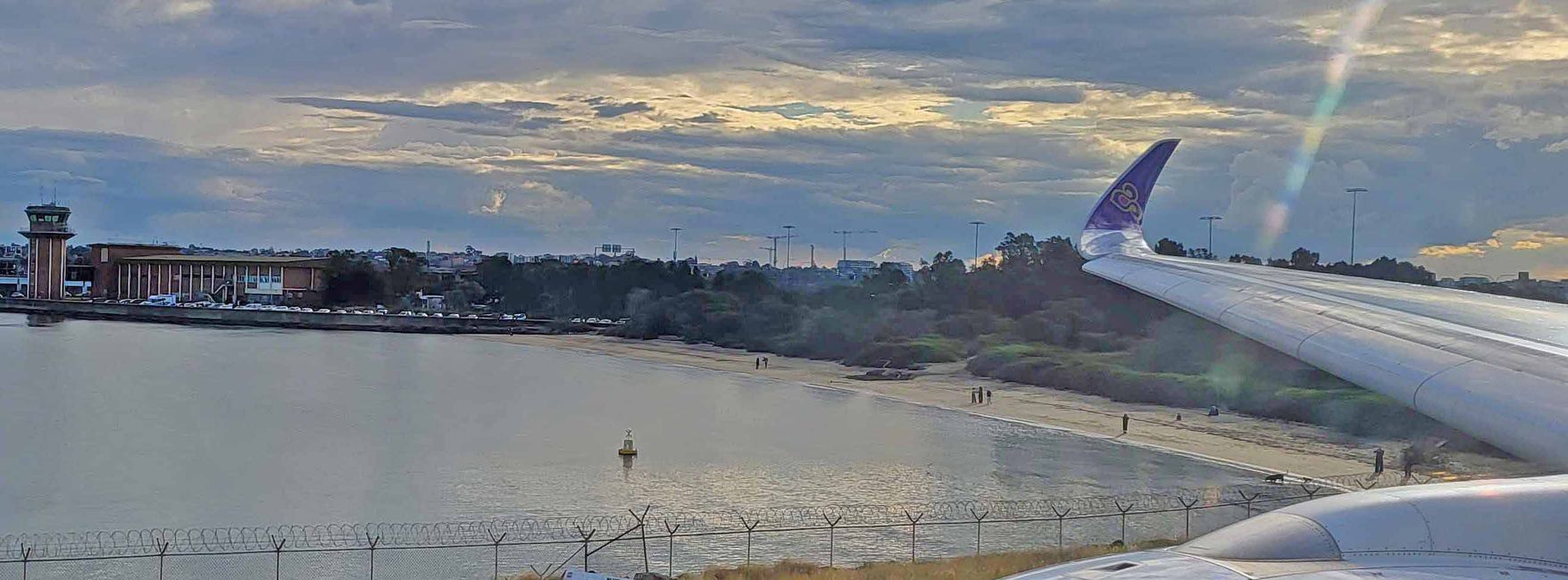 Strand bei der Startbahn in Sydney, an dem viele Leute winken