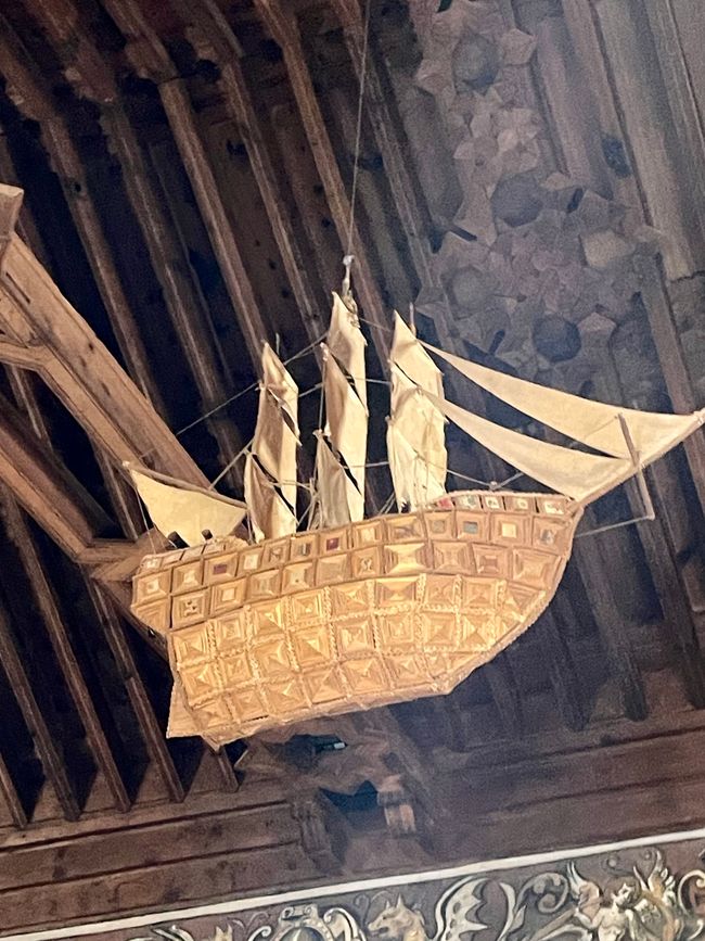A large wooden ship hangs from the ceiling.