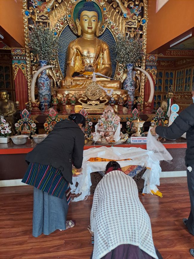 Offerings in front of the large golden Buddha figure.
