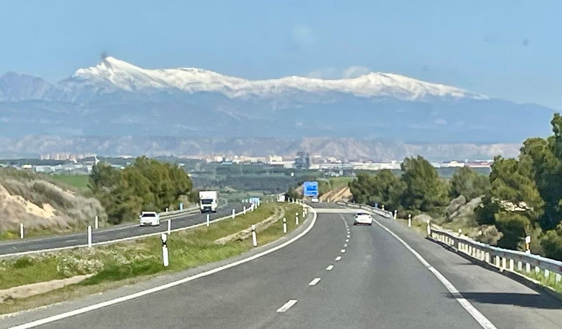 The snow-capped mountains of the Pyrenees rise behind Huesca.
