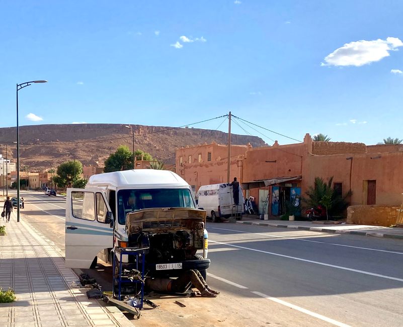 Moroccan car workshop during an engine repair - one guy is still under the car