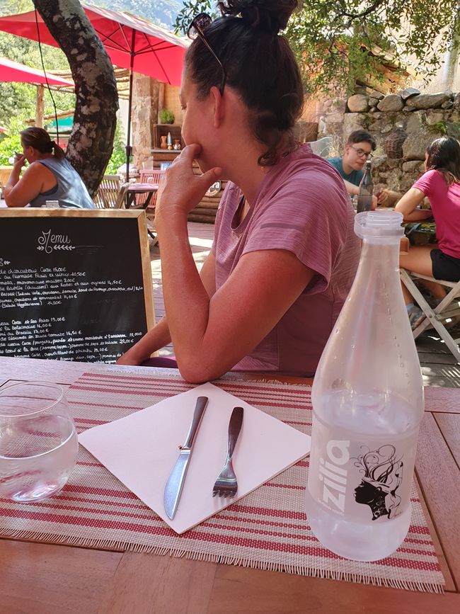 Agua de Zilia frente a una mujer pensativa al seleccionar comida
