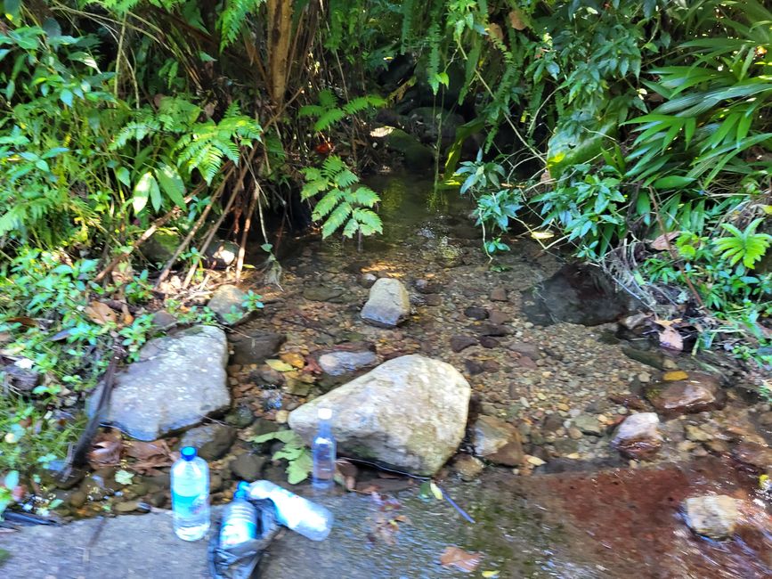 Wasserflaschen auffüllen im Fluss