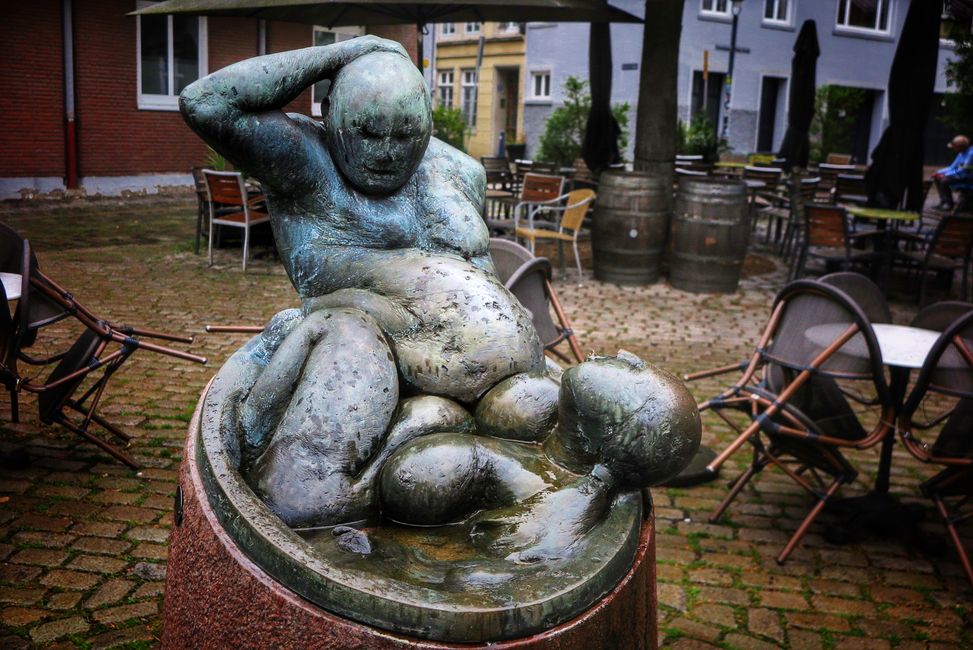 Die fröhlich Badenden, eine Frau spuckt dem fülligen Mann keck auf den Bauch.