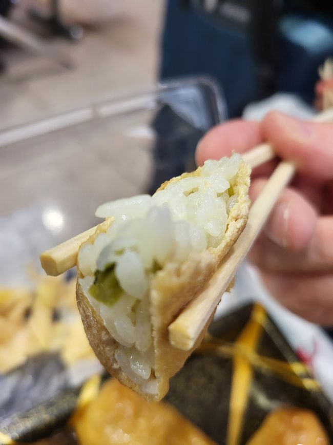 Sushi-Reis, oft gemischt mit mit Gemüße oder sonstigen,üllt in frittierte Tofutaschen (aburaage, 油揚げ), die in einer süßlichen Sojasoßen-Marinade gekocht wurden