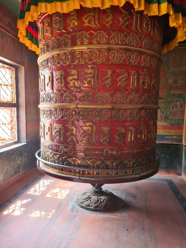 Eine große Gebetsmühle im Eingangsbereich des buddhistischen Klosters.