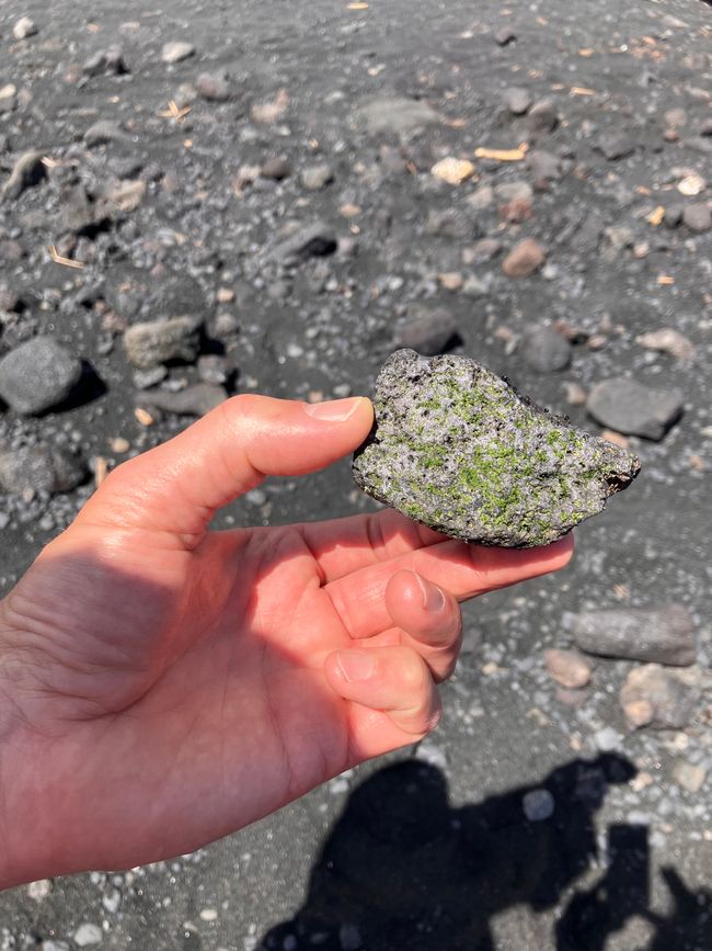 Black vulcanite rock mixed with smaragd minerals