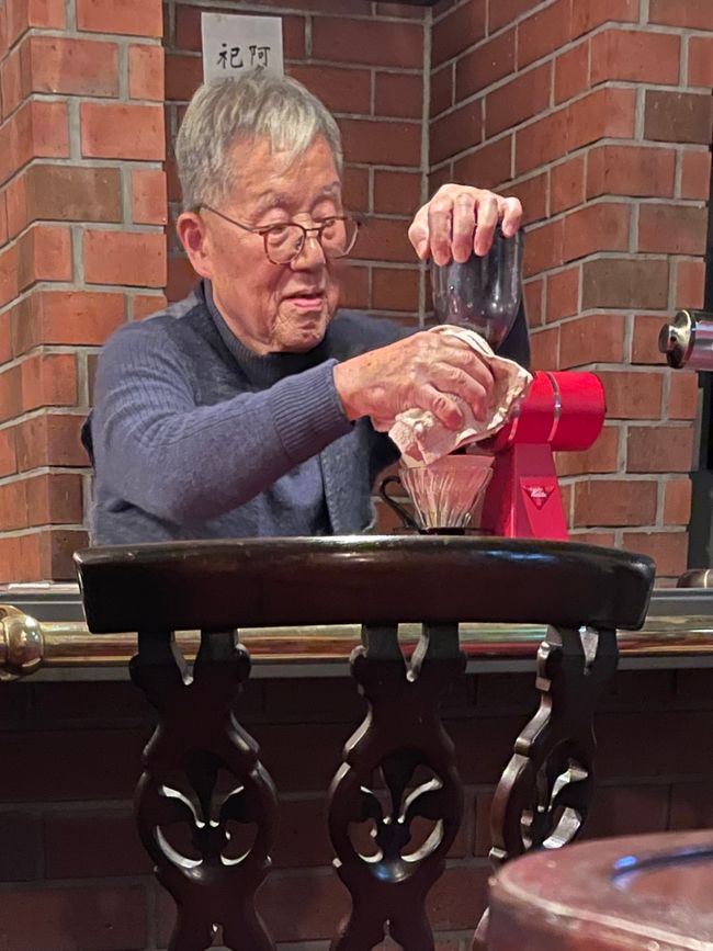 Der Besitzer putzt die Kaffeemühle 